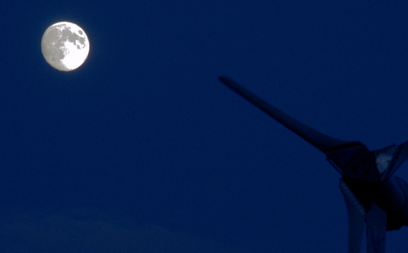 Wind turbine pointing at the moon.